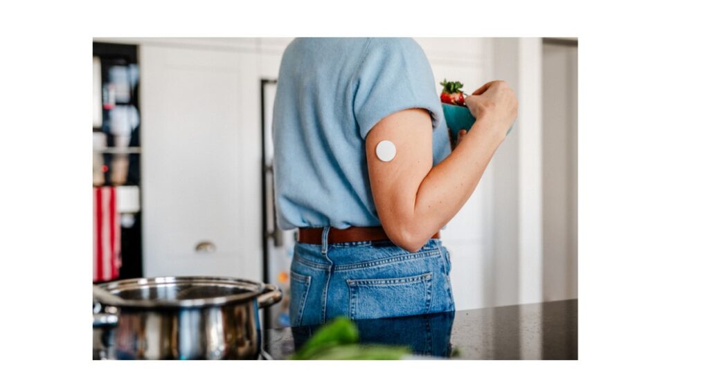 אישה עם חיישן סוכר רציף CGM במטבח